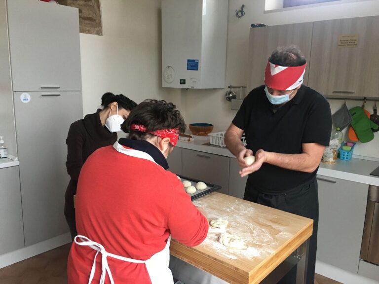 Foto: Tre ragazzi preparano l’impasto per le pizzette