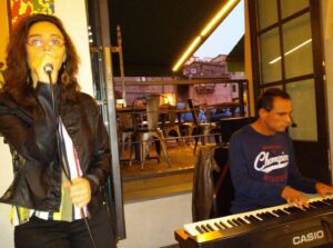 foto: un ragazzo e una ragazza intenti a suonare la tastiera e cantare